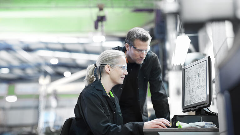 digitalisierung-smart-data-zwei-personen-rechner-fabrikanlage-arbeitssituation-gruen-gettyimages